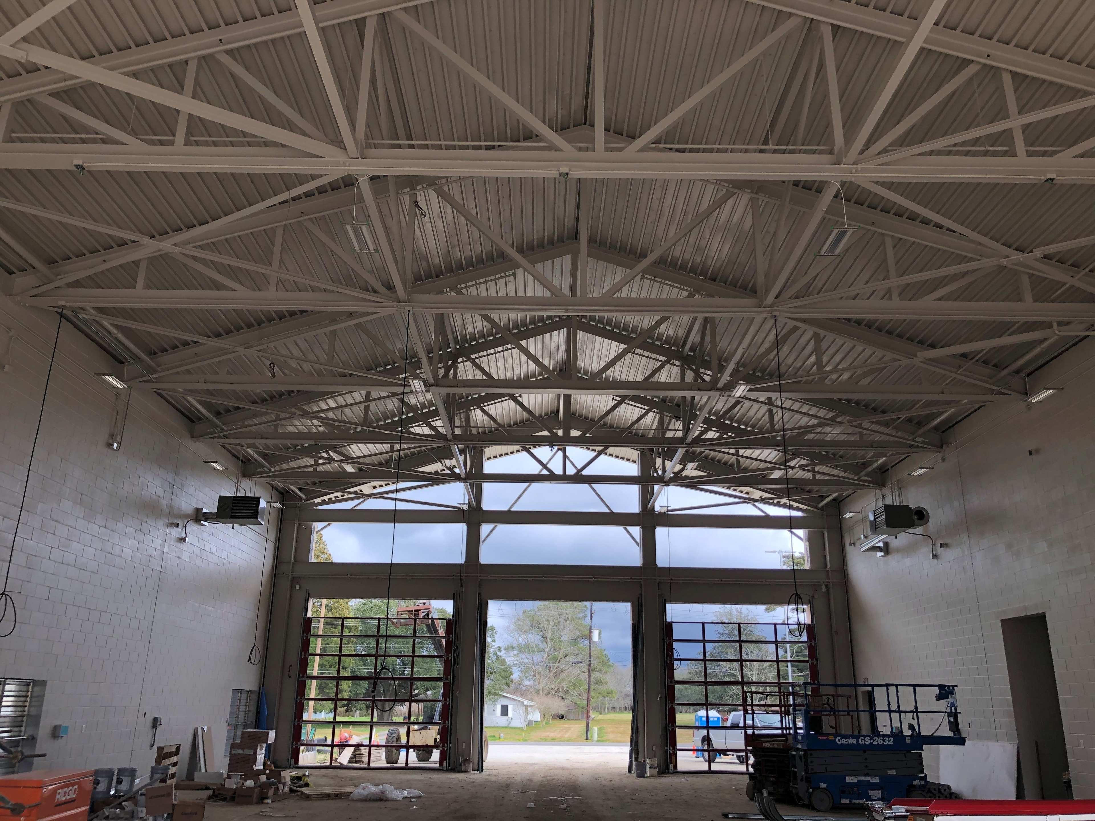 Fire Station 20 engine bay interior showing painted steel trusses and metal decking with three apparatus bays