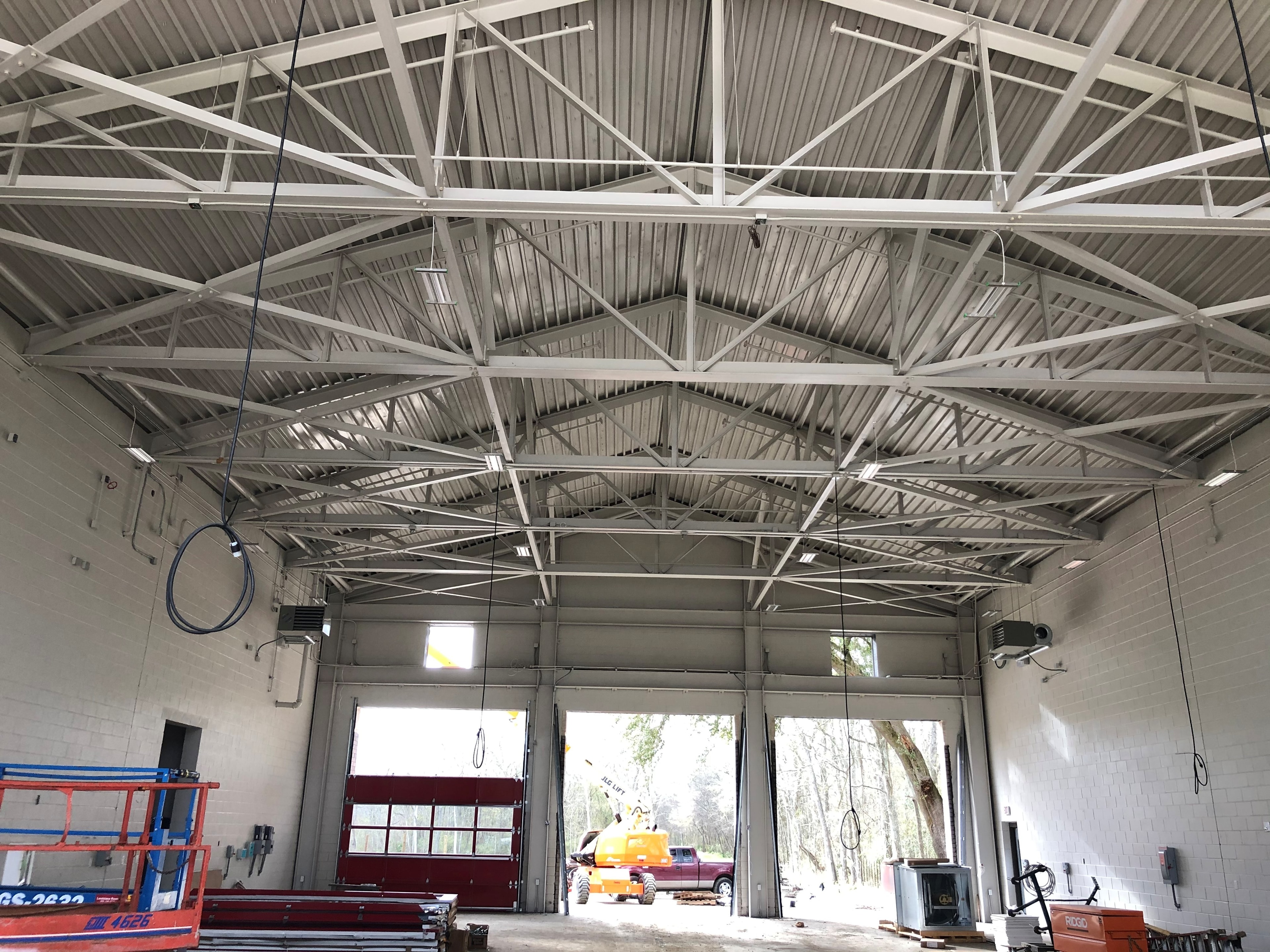 Fire Station 20 engine bay interior with steel trusses and metal decking viewed from apparatus floor