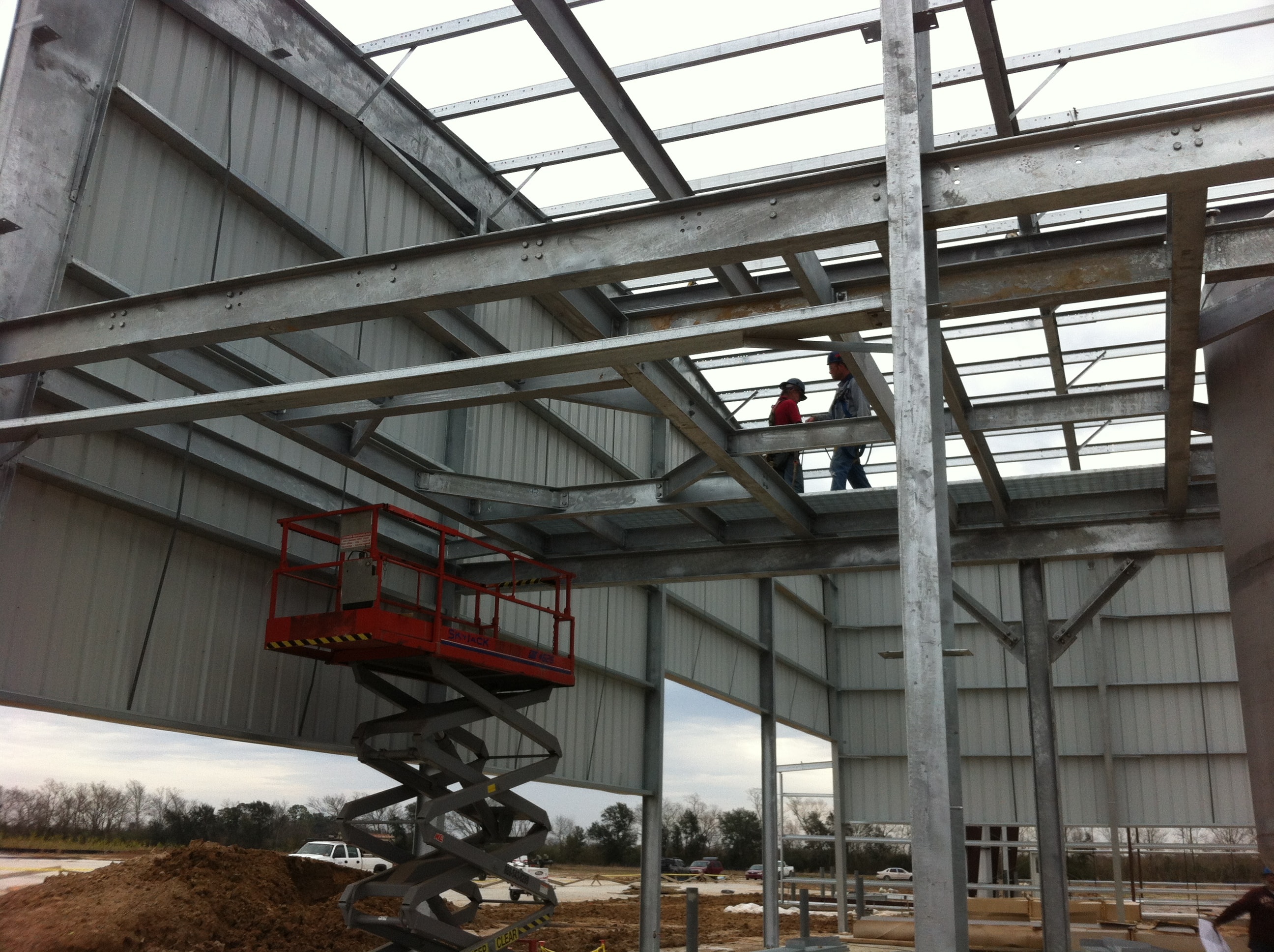 Halliburton galvanized mezzanine framing under construction with scissor lift