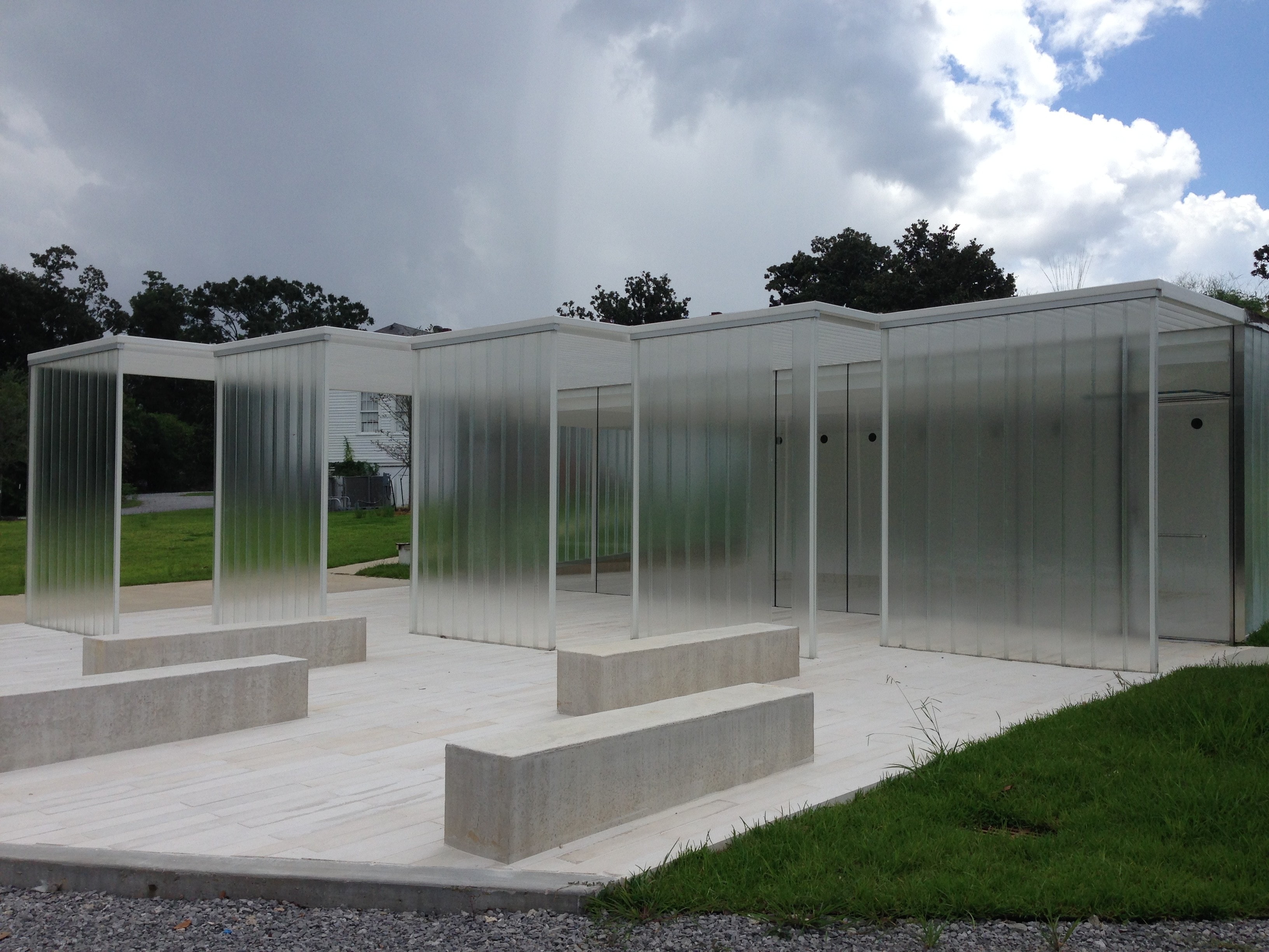 Magnolia Mound visitor center exterior with translucent polycarbonate panels and concrete seating