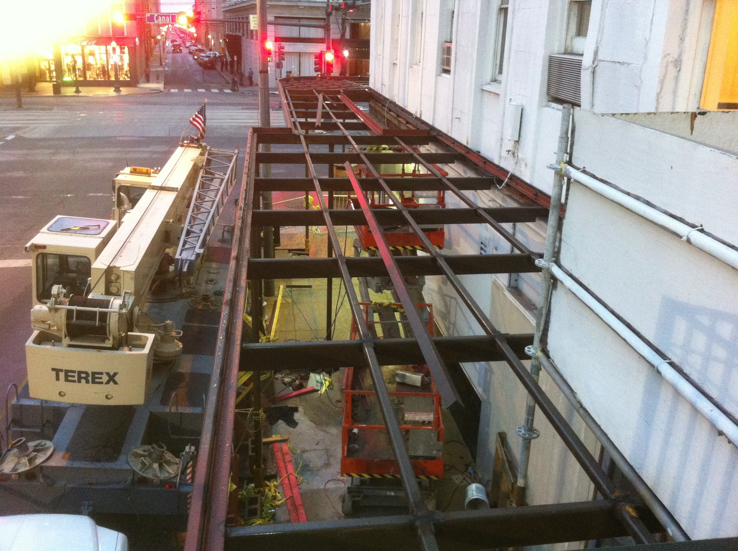 Maison Pierre Hotel first floor canopy steel framing under construction at night with Terex crane and Canal Street in background