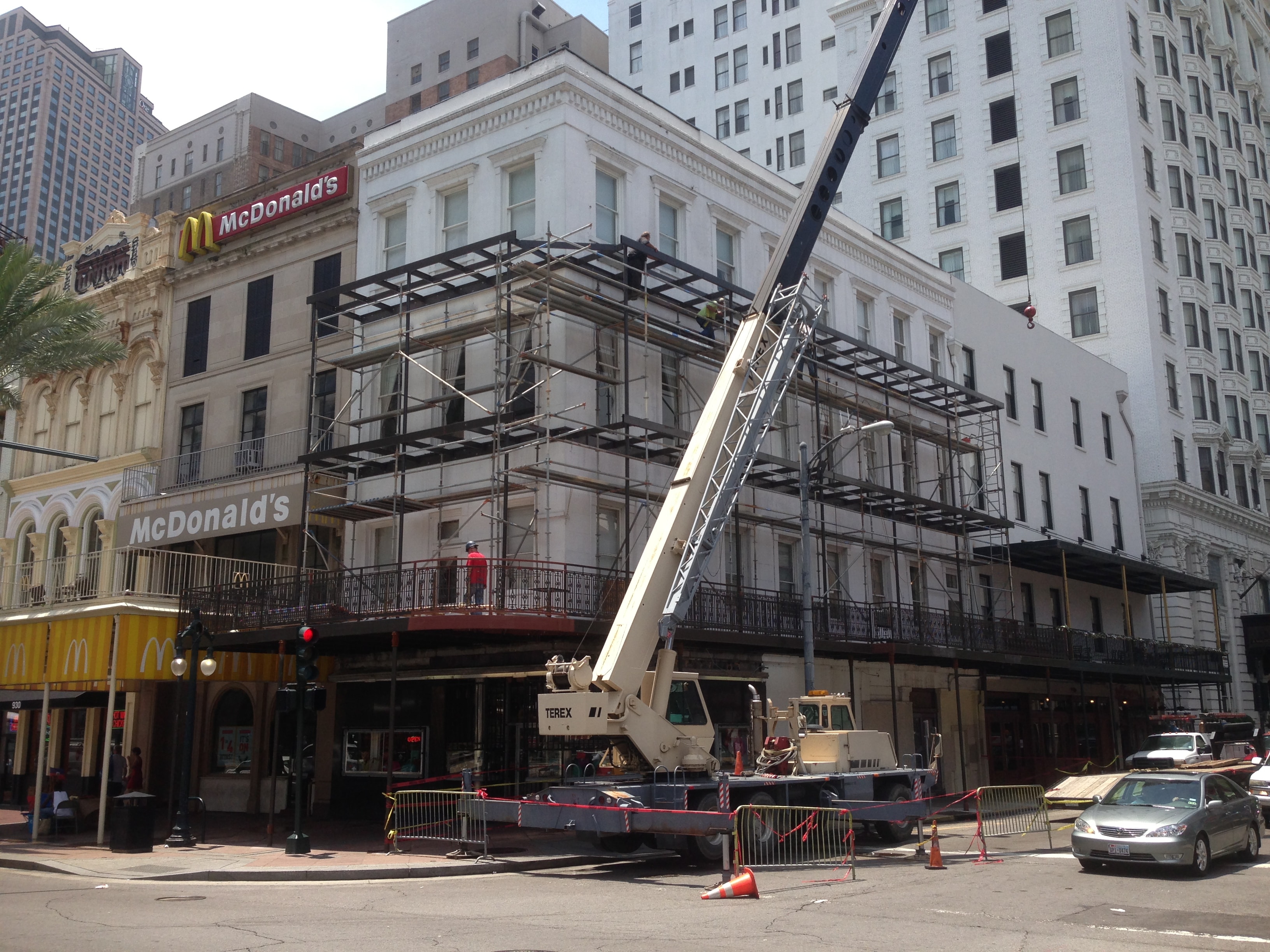 Maison Pierre Hotel full three-story balcony steel framing under construction with Terex crane and scaffolding on Canal Street