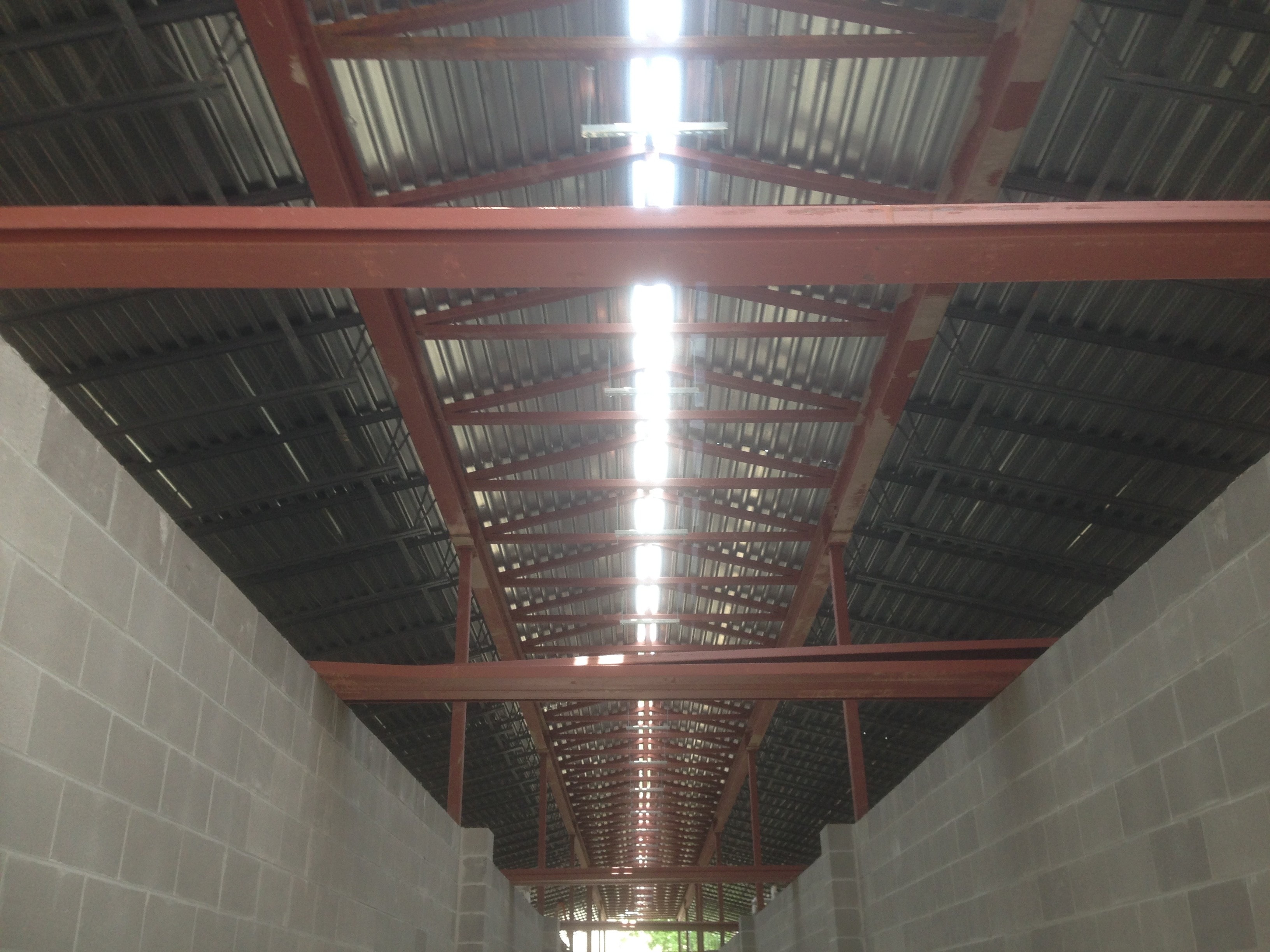 Norco Elementary Addition — interior corridor looking up at red steel trusses and metal decking