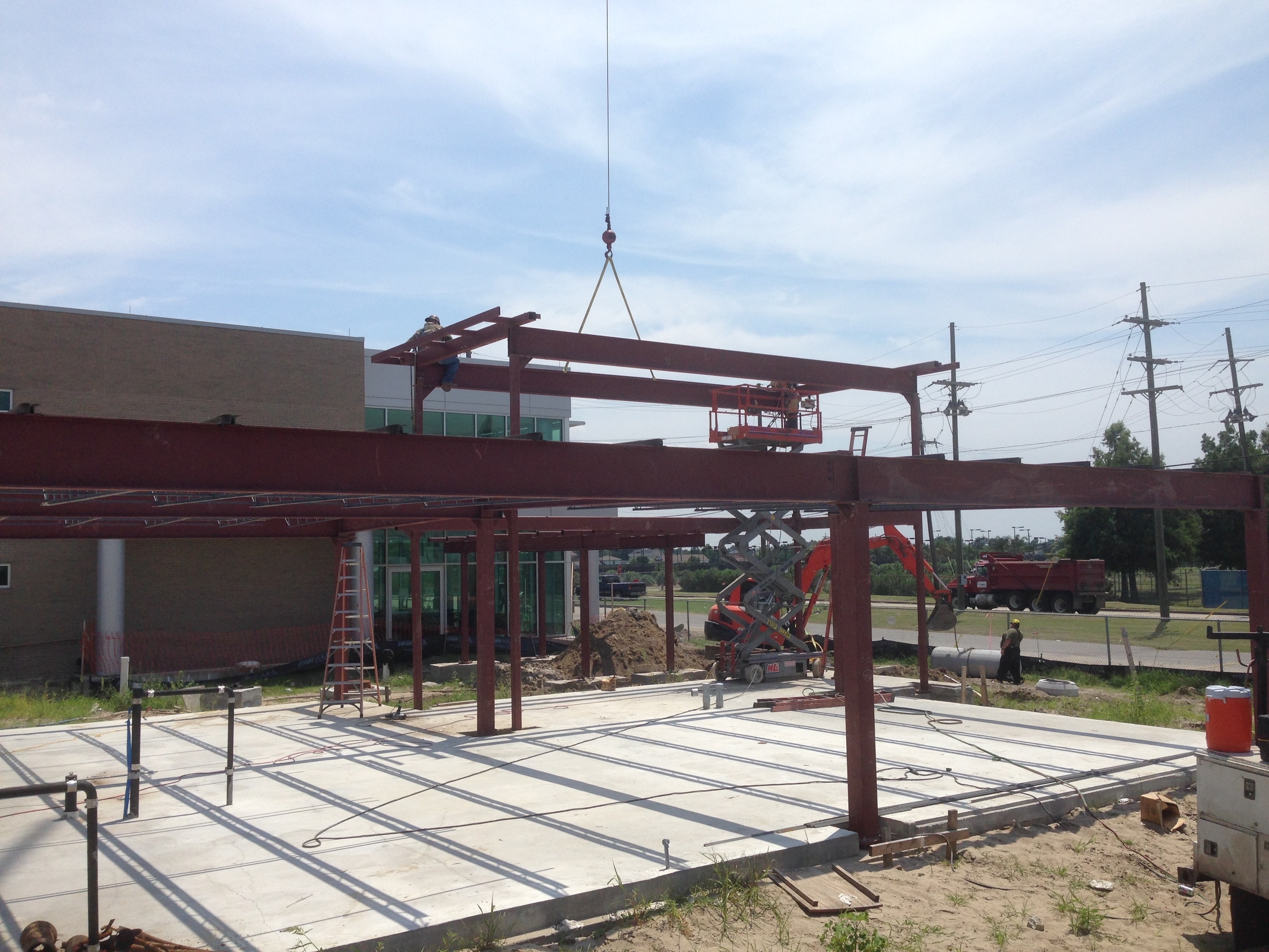 USF Business & Admin Building Addition — crane hoisting beam with bar joist and decking visible