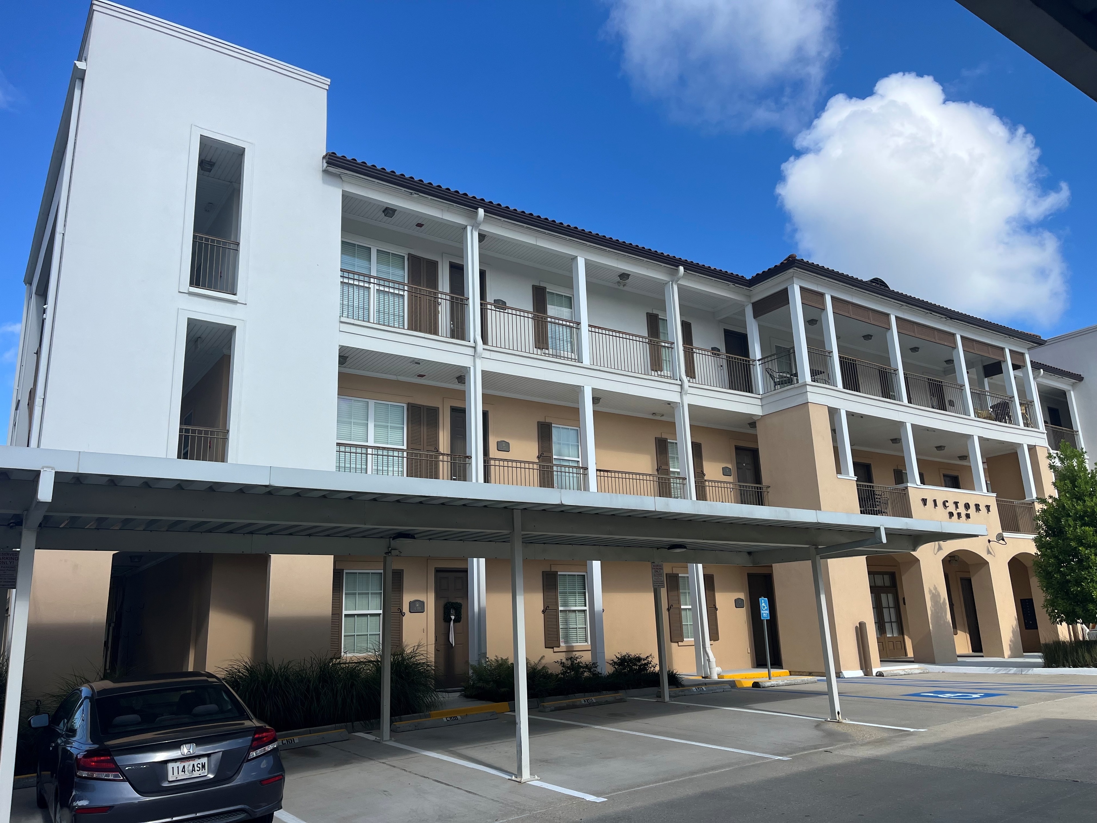 Victory Commons multi-story building with steel balcony rails and carport